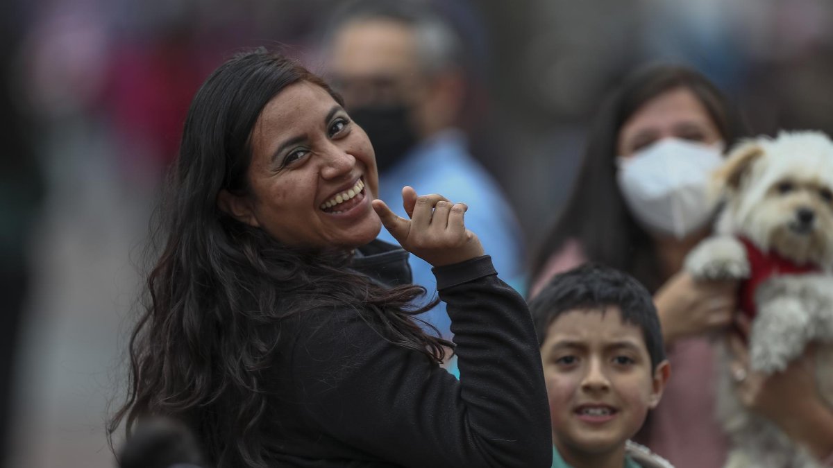 Grupos de personas con y sin mascarillas caminan hoy, por las calles de Quito.