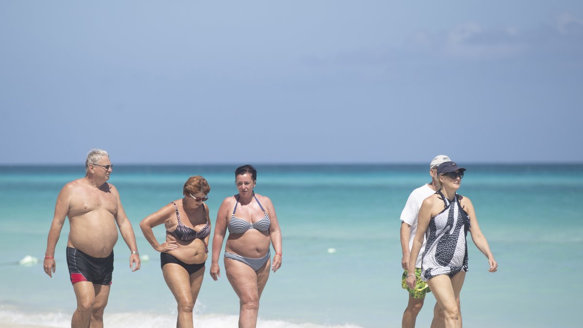Varias personas caminan por la playa hoy, lunes 2 de mayo de 2022, en Varadero, Cuba.