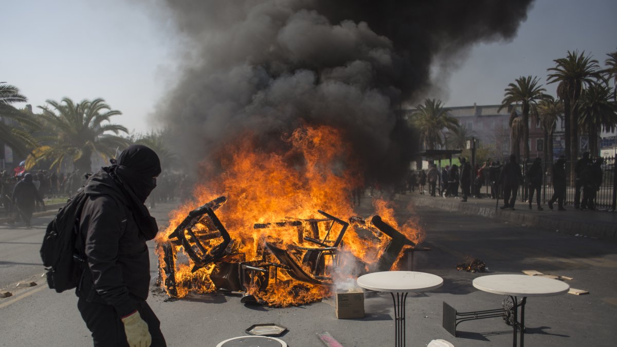 Manifestantes encienden, el 1 de mayo de 2022, una barricada durante una marcha con motivo del Día Internacional del Trabajo, en Santiago (Chile).