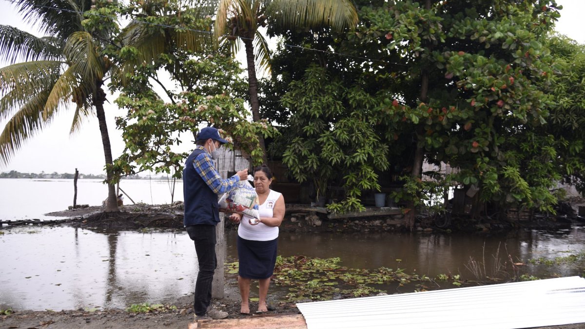 Brigada. Un funcionario del Municipio de Samborondón entrega una ración alimenticia a una habitante de un recinto de esa jurisdicción.