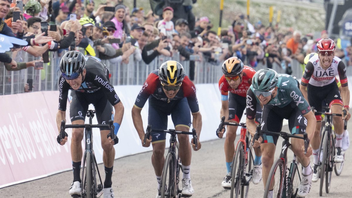 Richard Carapaz (c), ciclista ecuatoriano del Ineos, acelera en el sprint final de la novena etapa del Giro de Italia, en la que fue tercero. En primer lugar llegó el australiano Jai Hindley (d), del Bora Hansgrohe.