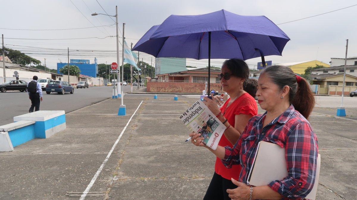 Con paraguas o periódicos, Ivón Pinzón y María de Lourdes Maridueña se cuidan del sol que calienta a la ciudadela 9 de Octubre donde el arborizado es deficiente.