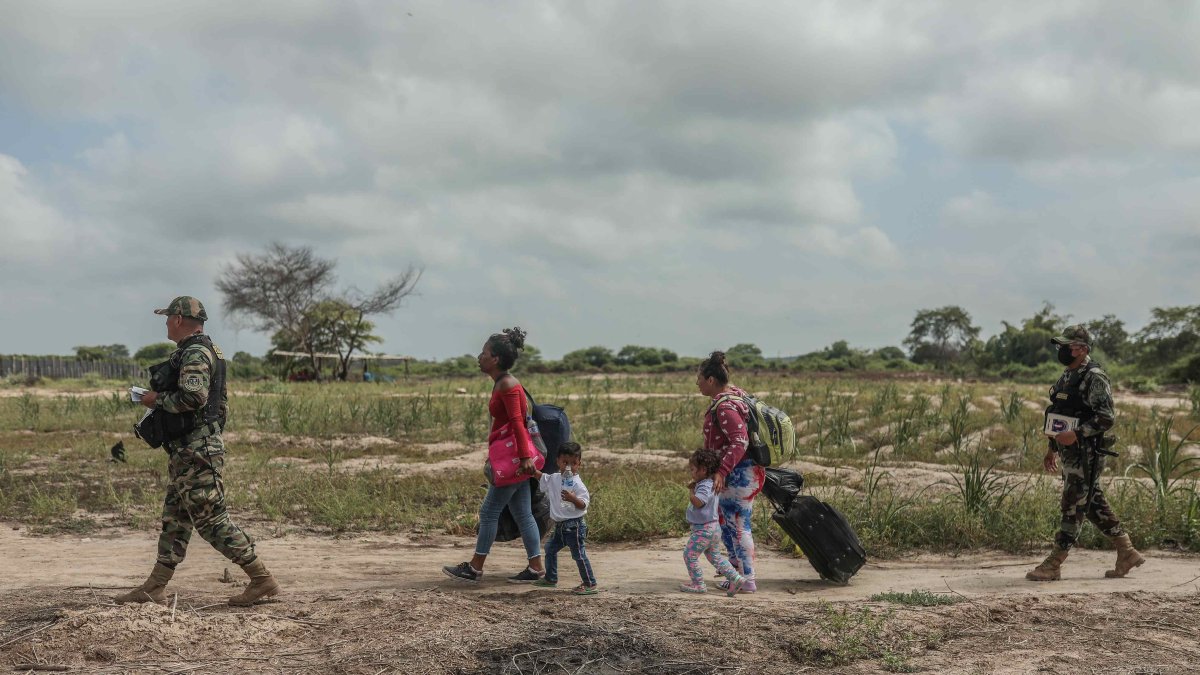 Miembros de la policía de Perú controlan el paso de migrantes venezolanos que intentan cruzar la frontera de Perú por la orilla del río Zarumilla, junto a Ecuador el 6 de mayo de 2022.