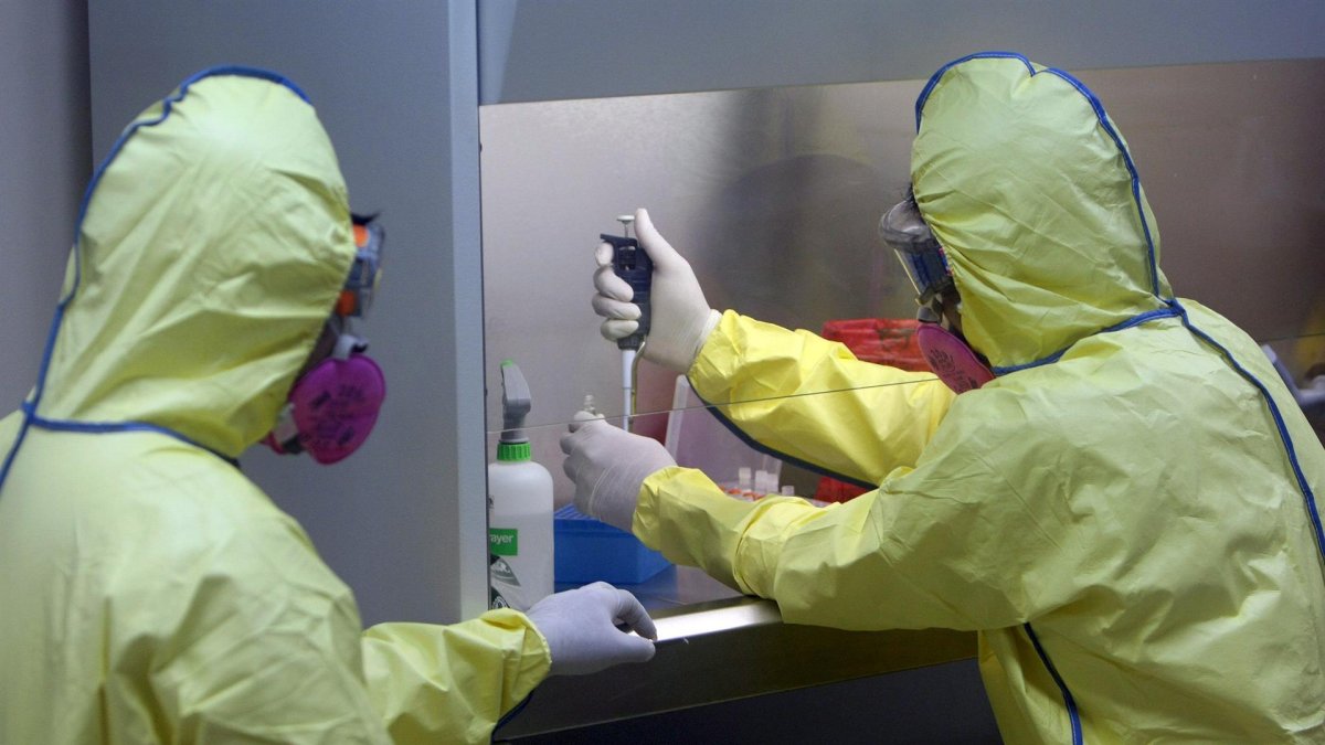 Referencial. Imagen de archivo de dos médicos con trajes protectores.