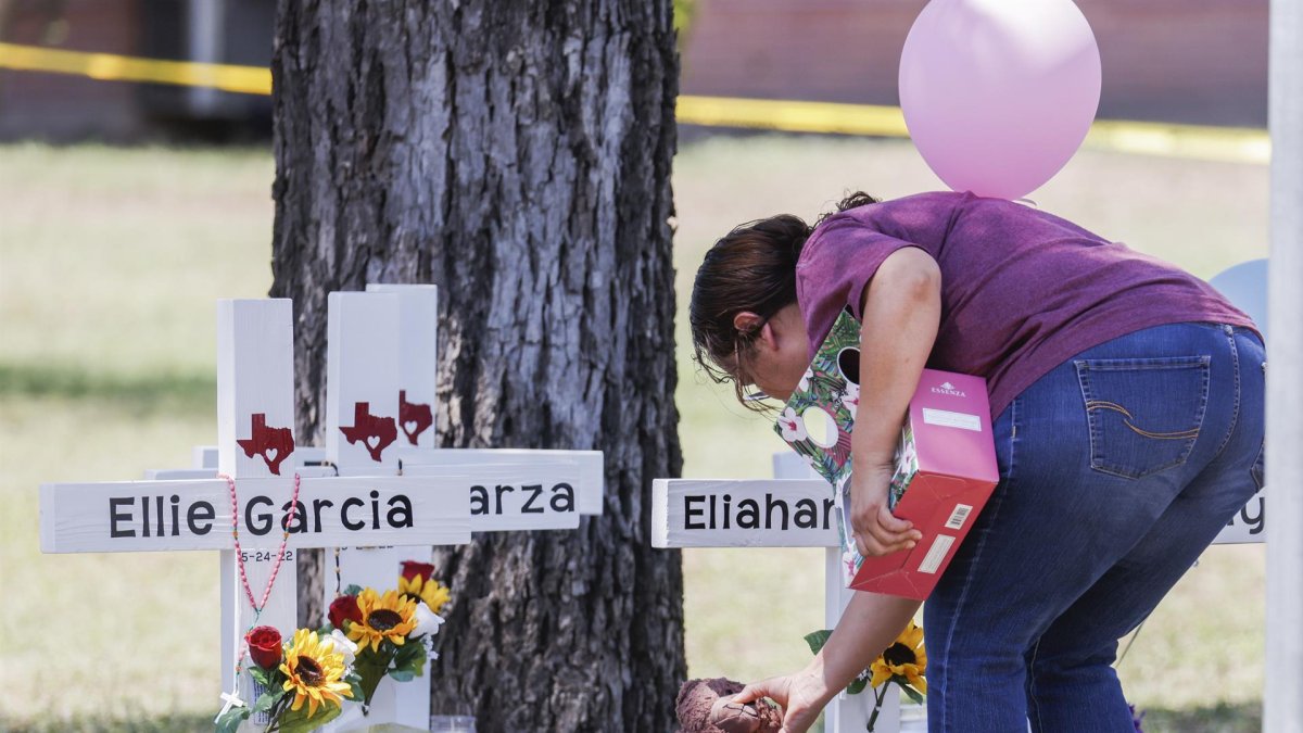 Una mujer coloca un animal de peluche junto a una cruz con el nombre de una víctima luego de un tiroteo masivo en la Escuela Primaria Robb en Uvalde, Texas, EE. UU., el 26 de mayo de 2022.