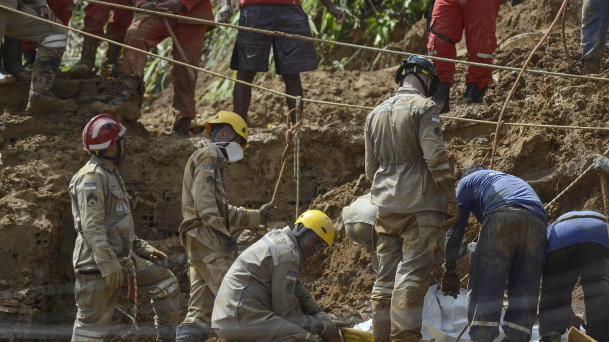 Bomberos trabajan en el área de un deslizamiento de tierra provocado por fuertes lluvias hoy, en el barrio Córrego do Jenipapo de la ciudad de Recife (Brasil).