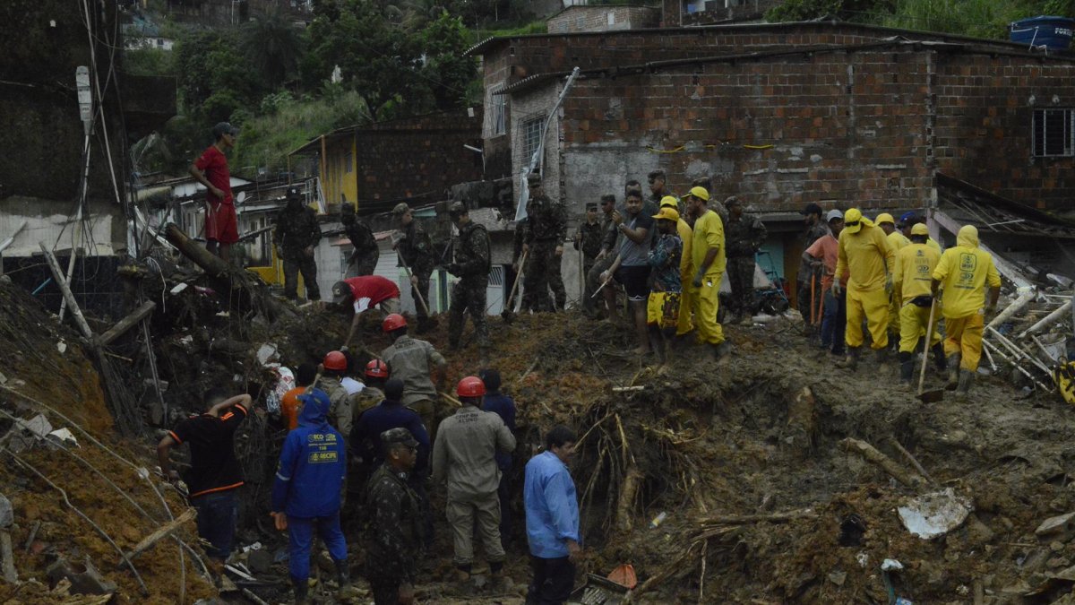 Bomberos, soldados del ejército y voluntarios trabajan en el área de un deslizamiento de tierra provocado por fuertes lluvias hoy, en el barrio Jardim Monteverde de la ciudad de Jaboatão dos Guararapes (Brasil