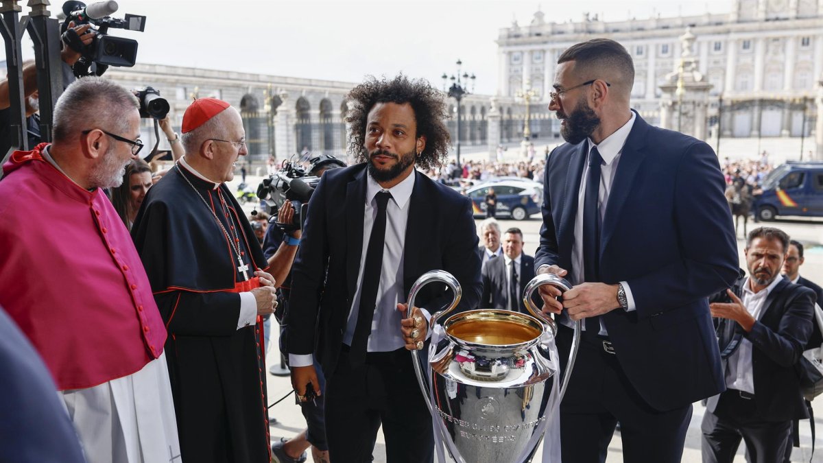 Los capitanes del Real Madrid Marcelo (i) y Karim Benzema (d) son recibidos por el arzobispo de Madrid, Carlos Osoro (2i), a su llegada a la Catedral de la Almudena, una de las paradas del recorrido realizado esta tarde por el equipo para celebrar su victoria en la final de la Liga de Campeones.