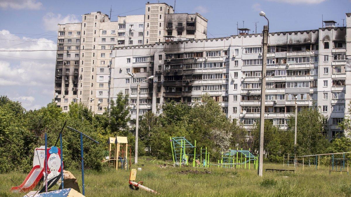Juegos infantiles frente edificios dañados por bombardeos rusos en Járkov