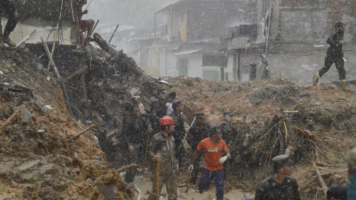 Bomberos, soldados del ejército y voluntarios trabajan en el área de un deslizamiento de tierra provocado por fuertes lluvias hoy, en el barrio Jardim Monteverde de la ciudad de Jaboatão dos Guararapes (Brasil).