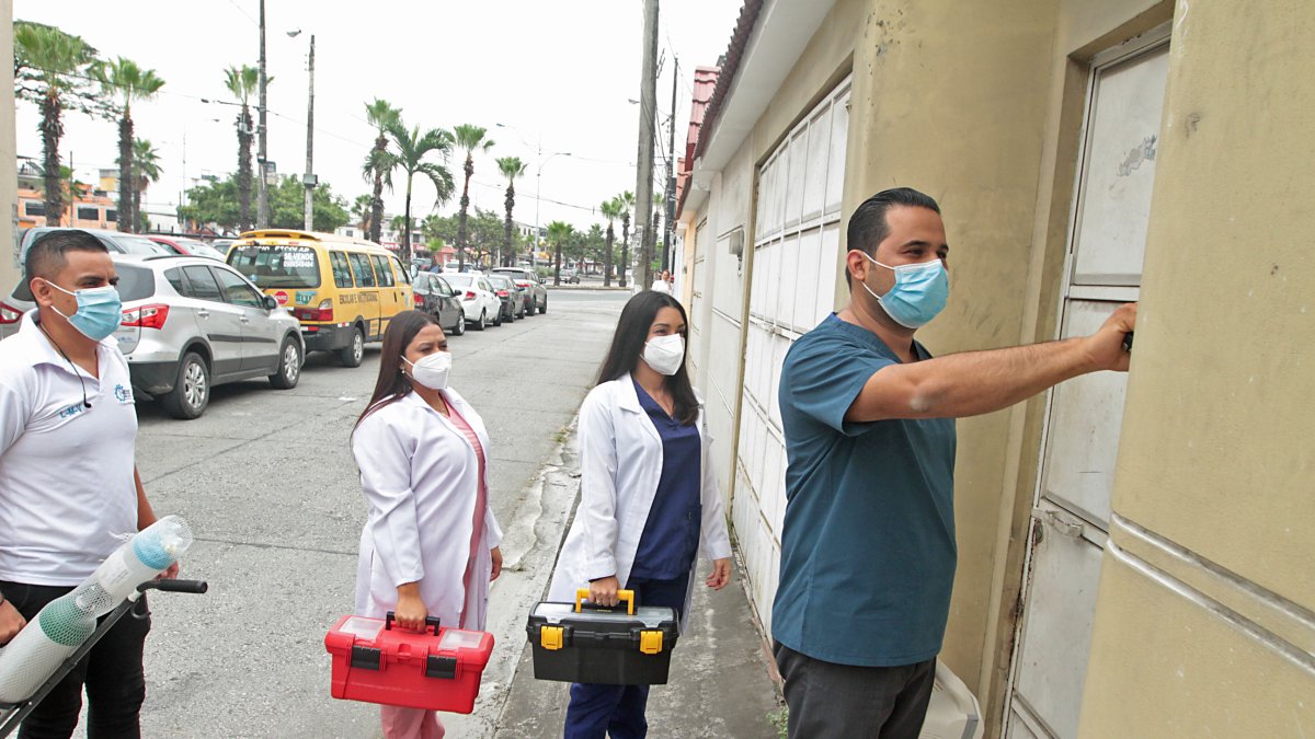 Atención. El doctor Mario Plaza toca la puerta en una casa del norte de Guayaquil para atender a un paciente.