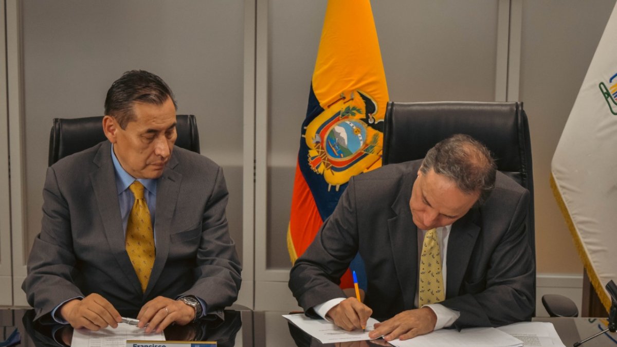 Francisco Cepeda, presidente del Consejo Directivo del IESS, y el ministro de Finanzas, Simón Cueva, durante el pago de parte de la deuda por salud.