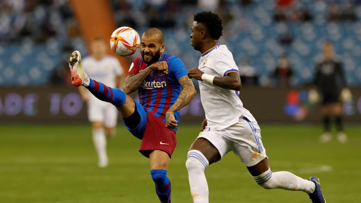 El delantero brasileño del Real Madrid, Vinicius Jr. (d), disputa el balón con su compatriota, el defensa del FC Barcelona, Dani Alves