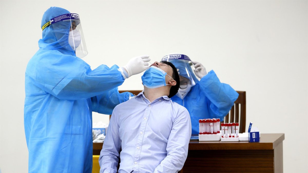 Un sanitario realizando una prueba PCR en Hanói