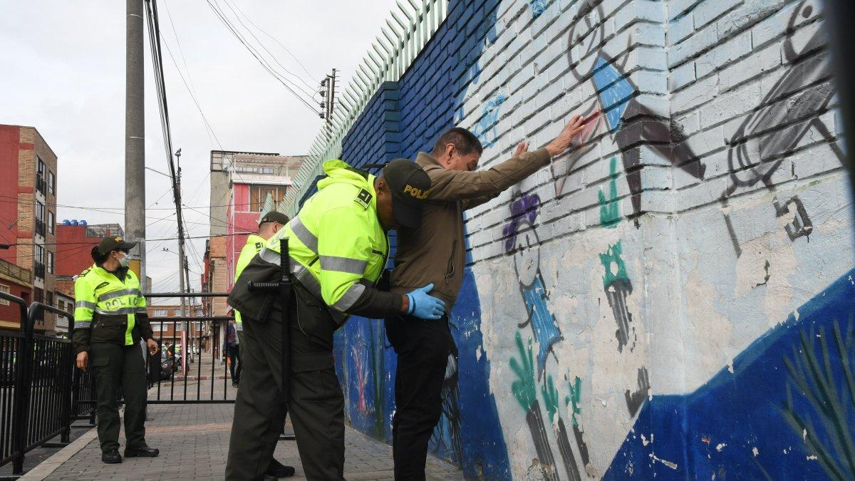 Agentes de la Policía registran a un individuo en Bogotá, Colombia