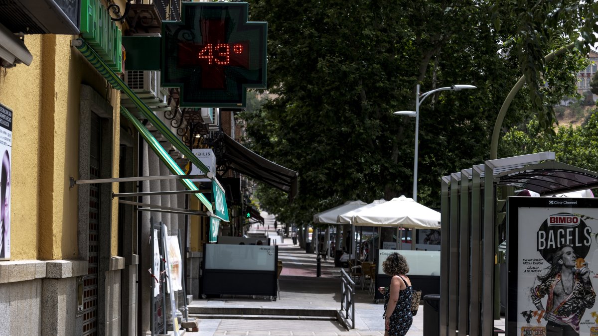 Una mujer pasa frente a una farmacia que marca 43 grados, en una imagen de archivo.