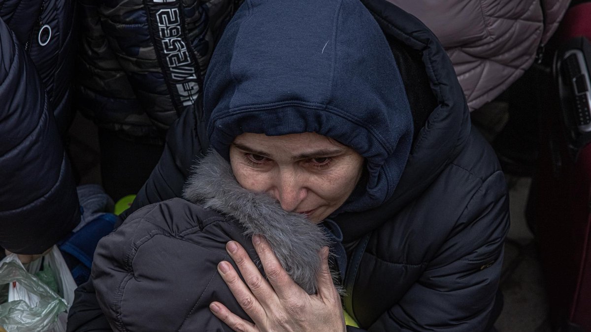 Una madre con su hijo trata de huir de Kiev
