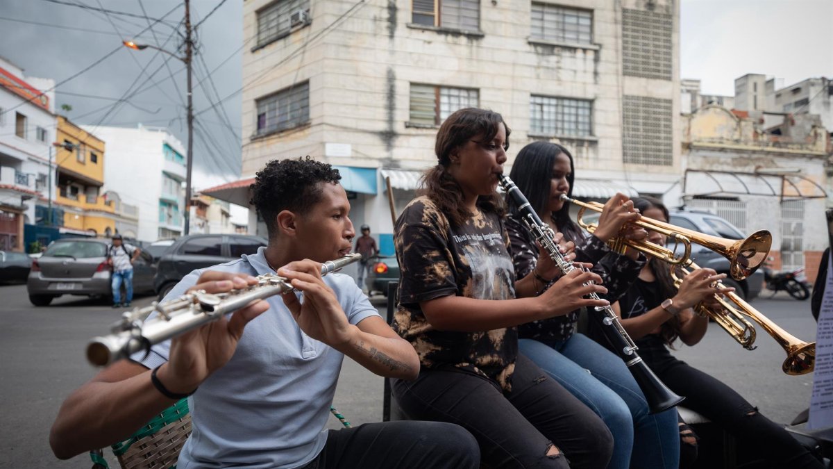 Alumnos del profesor de música Juan Manuel Mejías ensayan el 21 de junio de 2022, en una calle de Caracas (Venezuela).