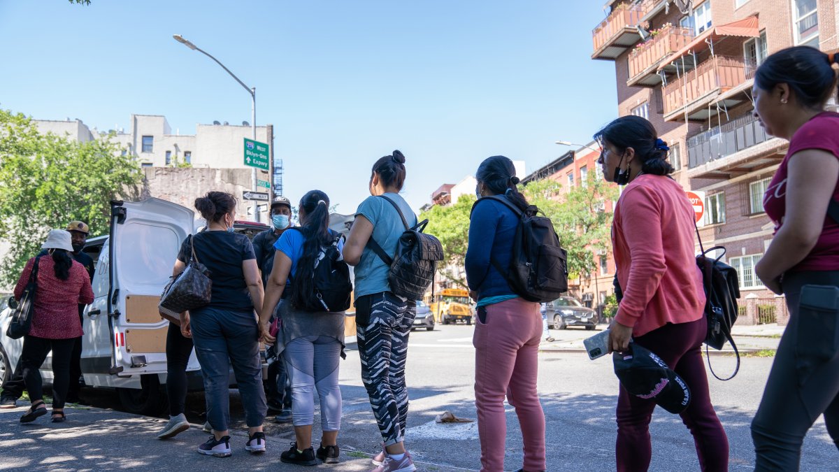 NUEVA YORK. Un grupo de mujeres jornaleras inmigrantes reciben comida mientras esperan ser contratadas para trabajos de limpiezas.