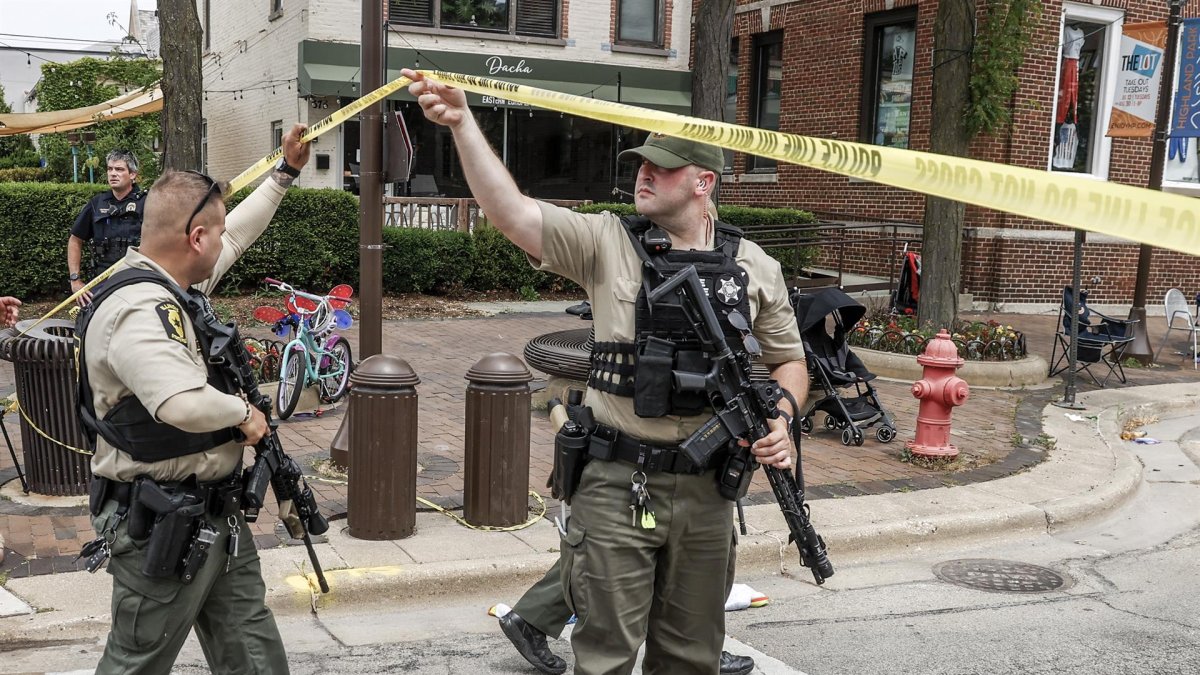 Un par de agentes policiales fue registrado este lunes al inspeccionar la escena de un tiroteo masivo, durante un desfile del 4 de julio, en Highland Park (Illinois, EE.UU.).