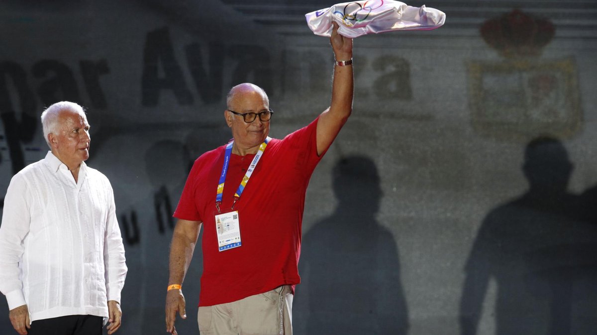 El presidente del Comité Olímpico Ecuatoriano (COE), Jorge Delgado, muestra la bandera de la Organización Deportiva Bolivariana (Odebo) junto a su presidente Baltazar Medina, el 5 de julio de 2022, durante la clausura de los XIX Juegos Bolivarianos en Valledupar (Colombia).