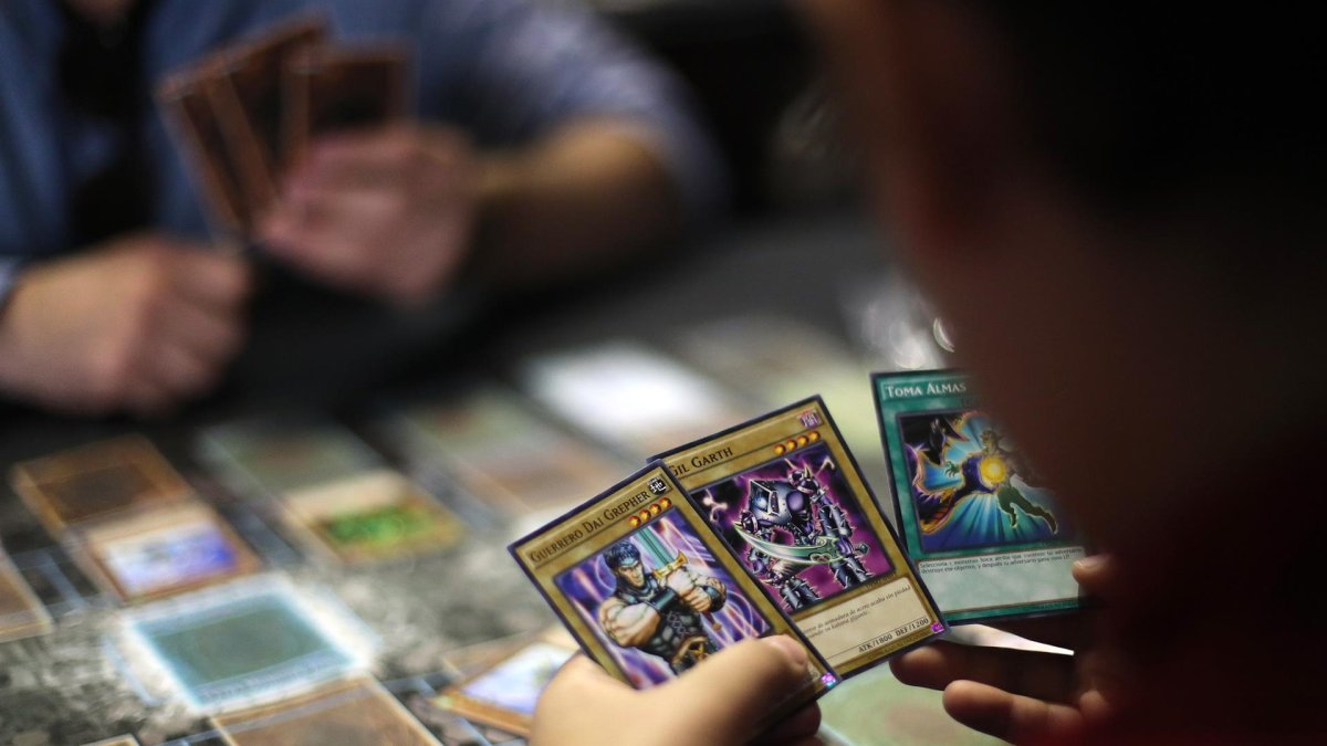 Dos jóvenes juegan cartas de la serie manga Yu-Gi-Oh!
