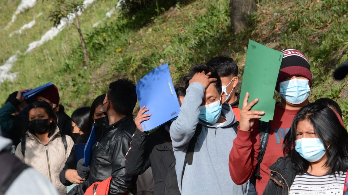 Personas esperando que reciban sus carpetas laborales.