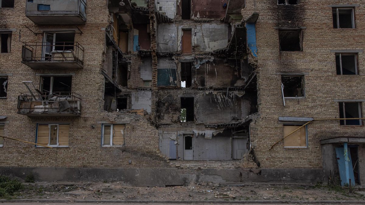Niño jugando frente a un edificio destruido en Ucrania por los bombardeos rusos