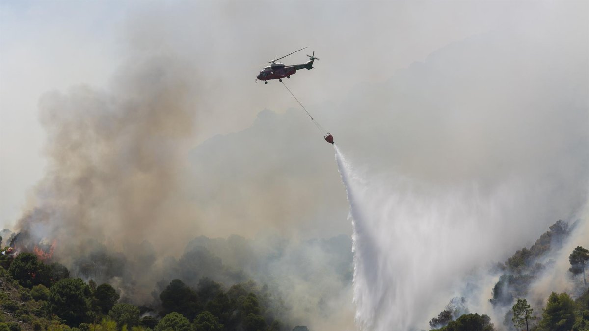 Un helicóptero de extinción vierte agua en el incendio forestal iniciado en la sierra de Mijas, Costa del Sol, sur de España.