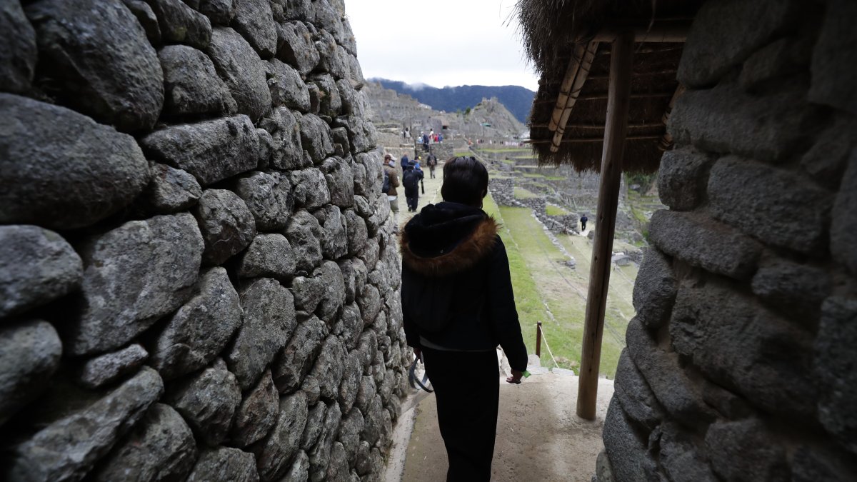 Fotografía de archivo en la que se registró a un grupo de turistas al recorrer la ciudadela inca de Machu Picchu (Perú).