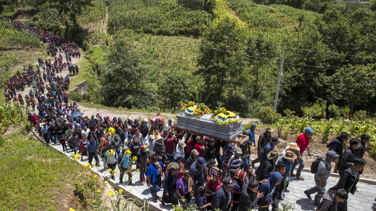 Vecinos y familiares asisten al entierro de los restos del menor Pascual Melvin Guachiac Sipac de 13 años, en el cementerio de la aldea Tzucubal, Nahualá (Guatemala). EFE/ 
