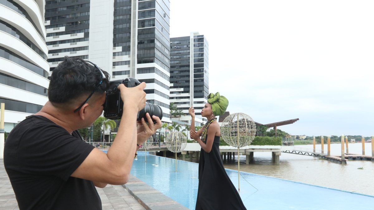 Fotógrafo con modelo posando en Puerto Santa Ana con el fondo del río Guayas.