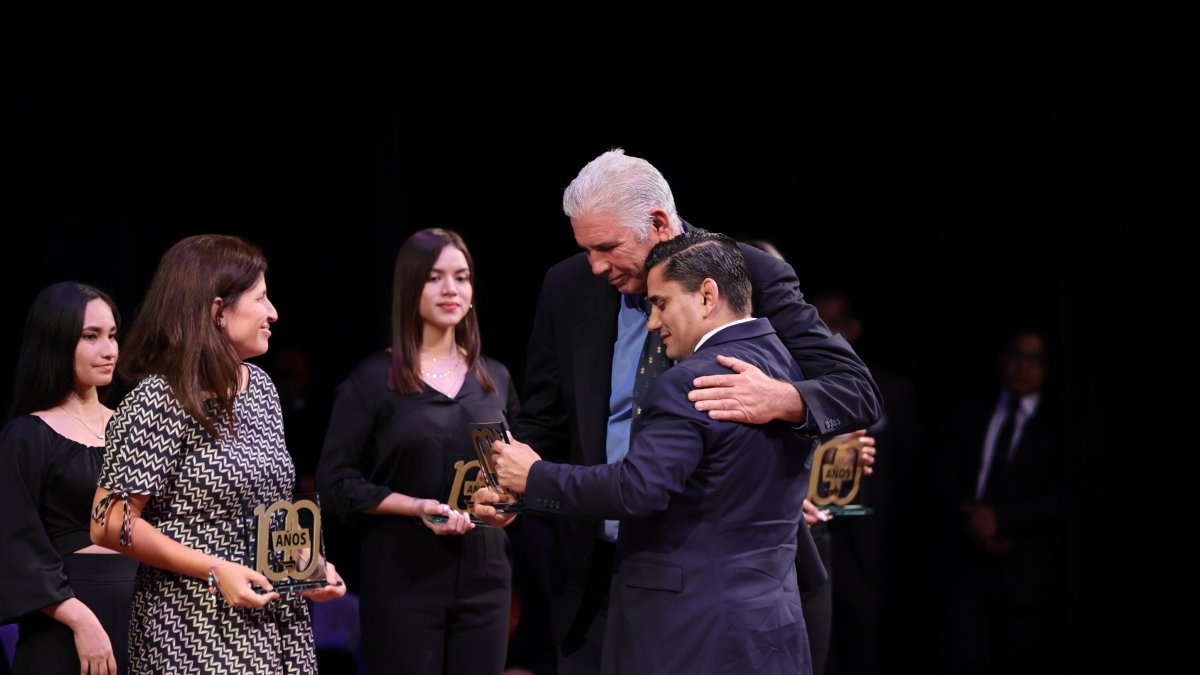 Andrés Gómez, extenista, recibe un reconocimiento de Roberto Ibáñez, presidente de Fedeguayas, mientras la ajedrecista Martha Fierro observa.