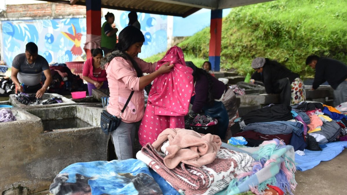 Las mujeres clasifican la ropa por el tipo de tela y color para lavarla por separado.