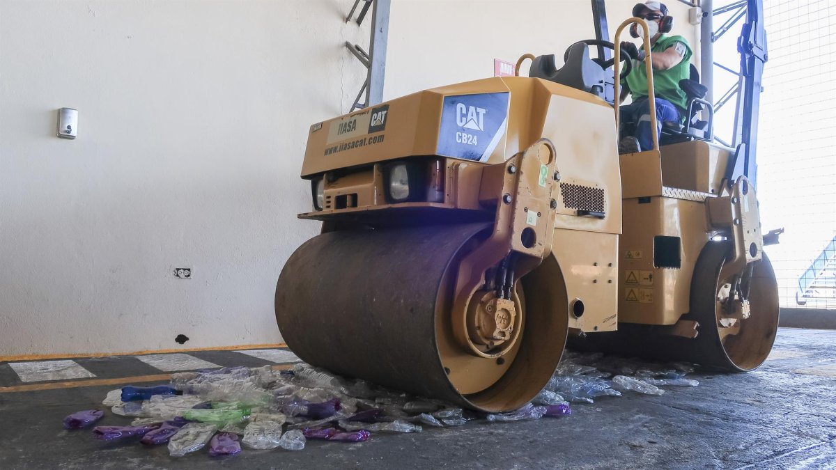 Una máquina aplanadora pasa por encima de decenas de botellas de plástico para iniciar el proceso de reciclado, el 22 de julio de 2022, en Galápagos (Ecuador).