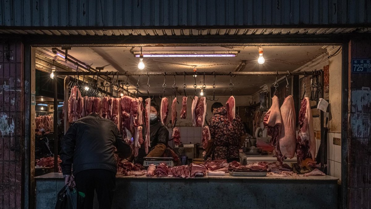 Una mujer vende carne en un mercado de un área residencial de Wuhan, China.