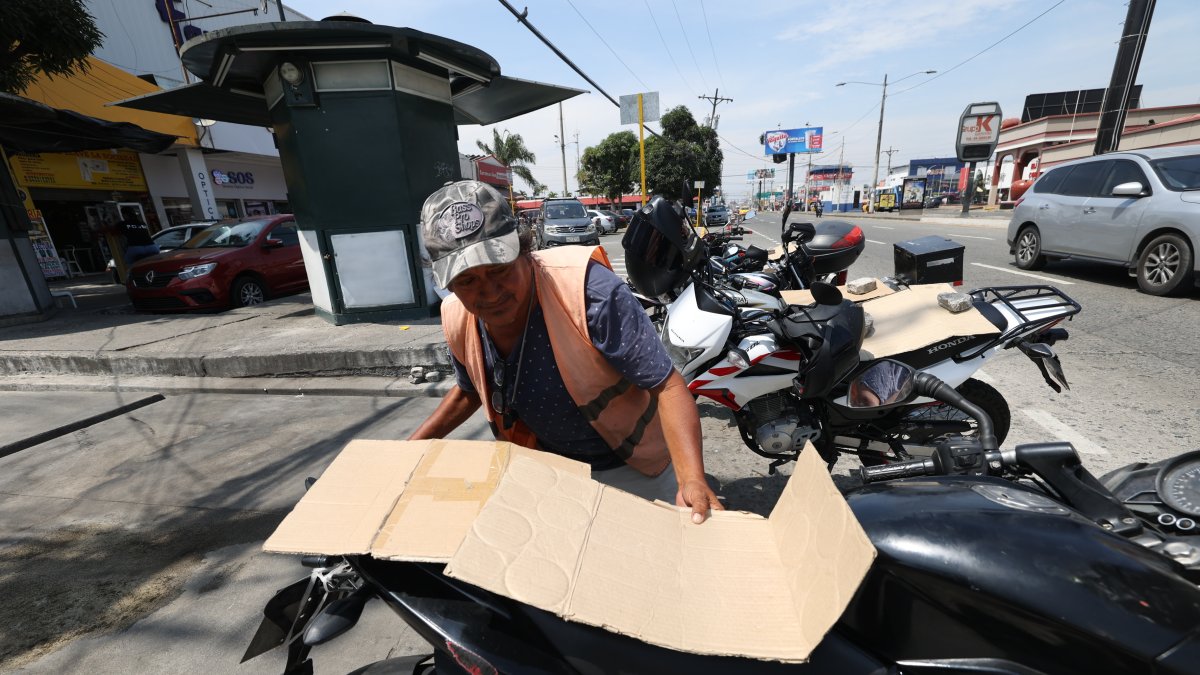Motos. En días con sol, Freddy Mazón recurre a cartones para colocar sobre los asientos de las motos que cuida. Así se gana más ‘voluntad’ de quienes confían en su labor.