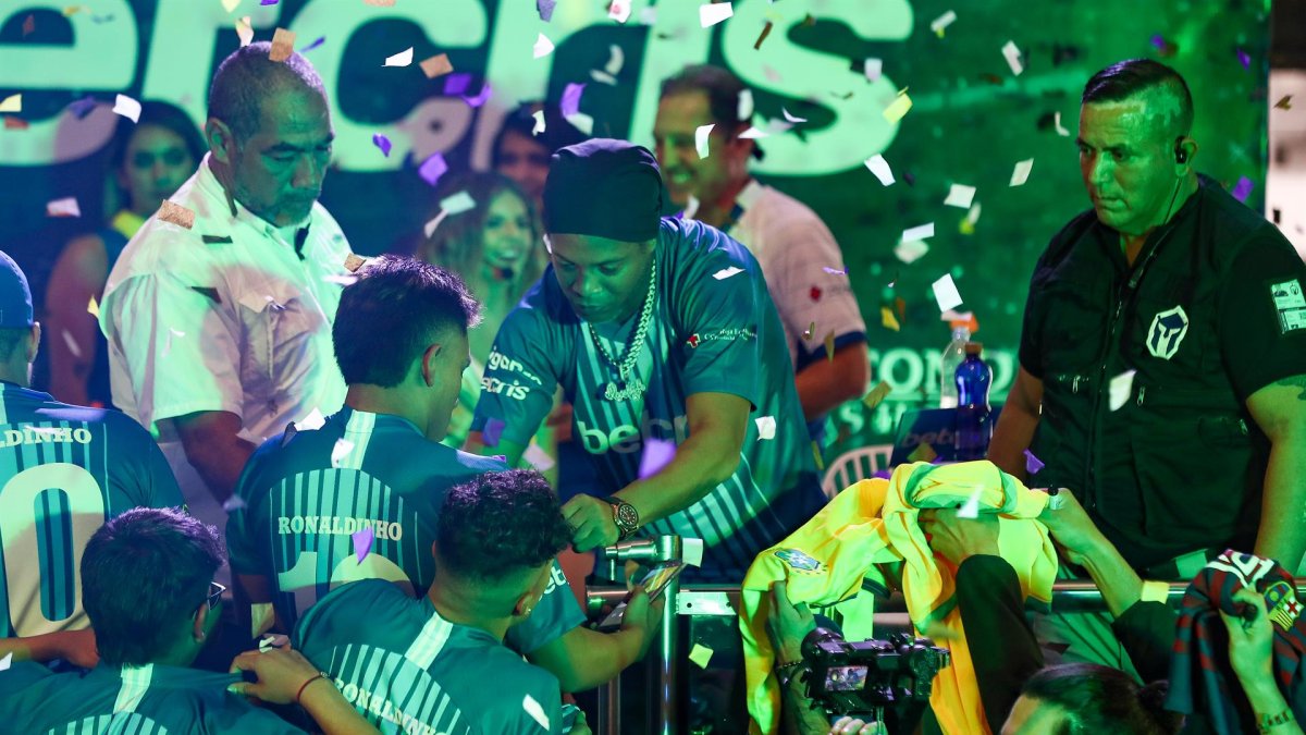 El ex futbolista brasileño Ronaldinho Gaúcho (c) participa como invitado en un concurso de fútbol-tenis y de habilidades dedicado a su figura, hoy, en un concurrido centro comercial de Quito (Ecuador).