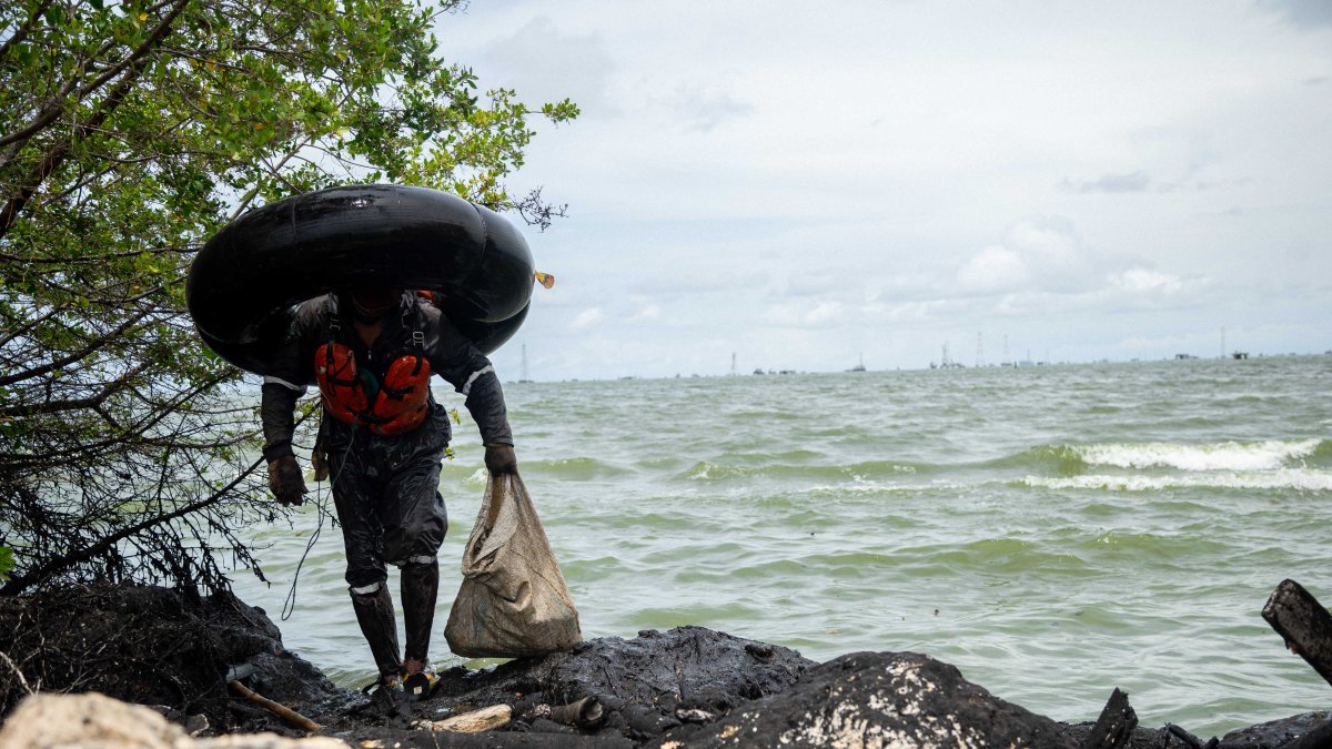 Un hombre se gana la vida entre restos petroleros sobre la costa oriental del Lago de Maracaibo.- HENRY CHIRINOS