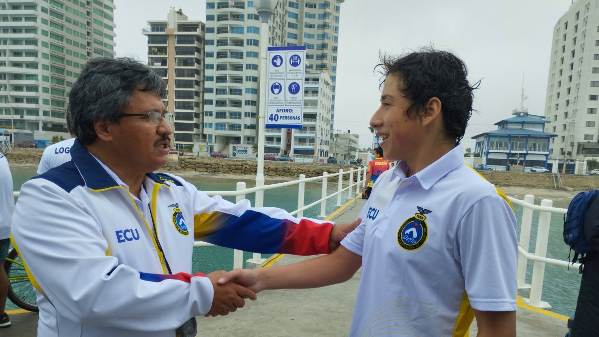 Juan Patricio Aguirre (d), nadador ecuatoriano, recibe la felicitación de su entrenador Rafael Maldonado tras el logro.