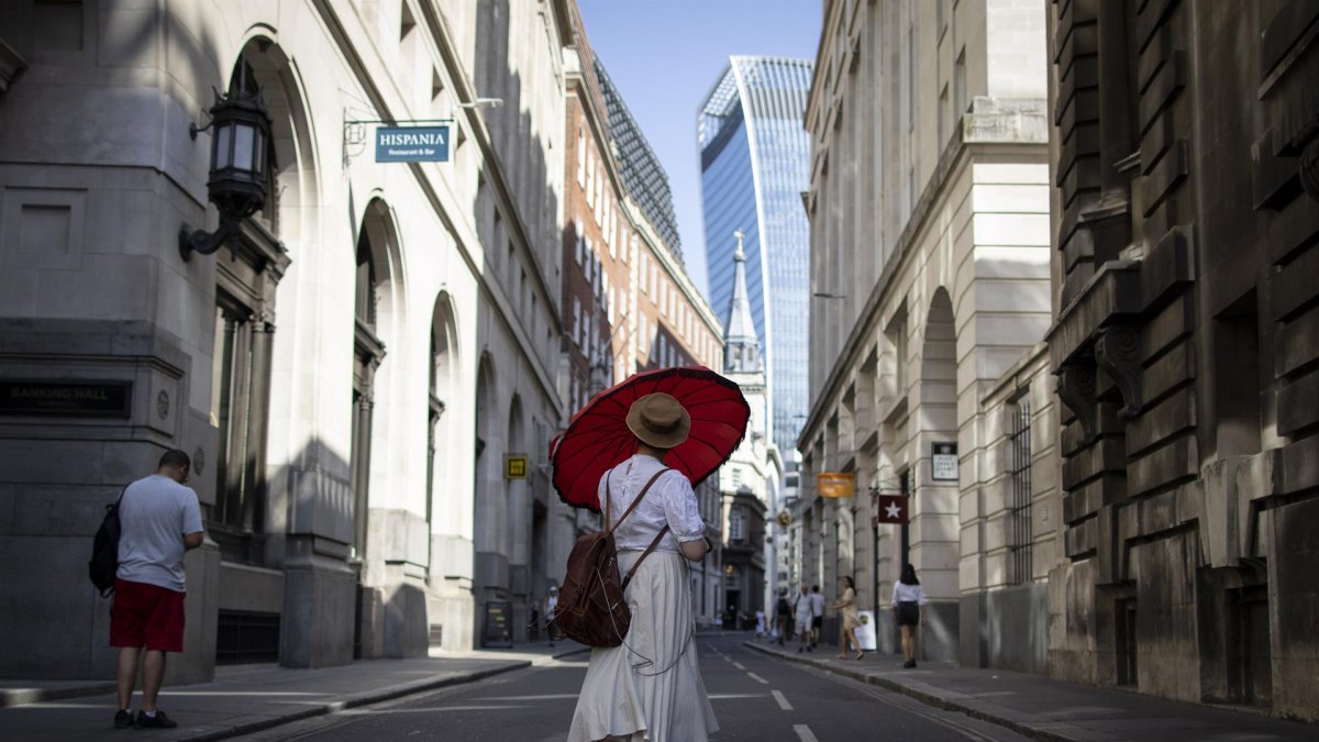 Una mujer usando un paraguas para protegerse del sol en el distrito financiero de la ciudad de Londres, Reino Unido, el pasado mes de julio.