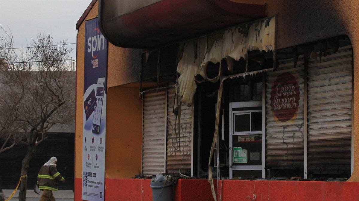 Bomberos trabajan en una tienda que fue incendiada por personas armadas hoy en Ciudad Juárez, estado de Chihuahua (México). EFE/Luis Torres
