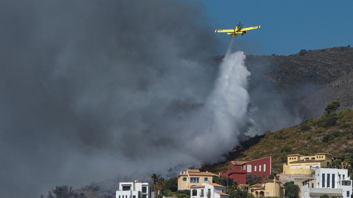 Una avioneta descarga agua sobre el fuego originado en Vall d'Ebo, provincia española de Alicante.