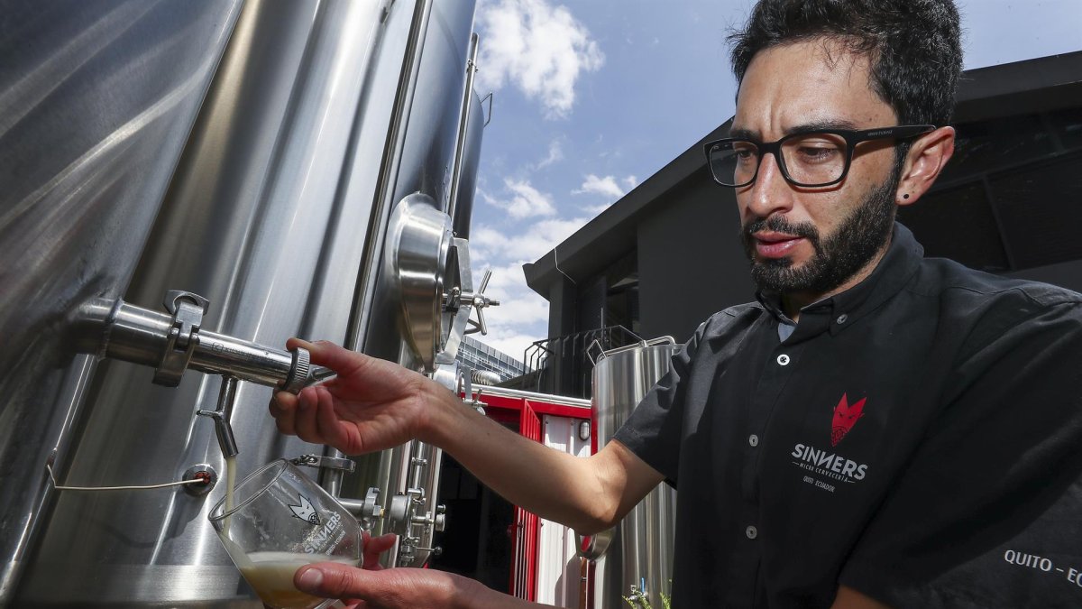 El gerente de producción de Sinners Micro Cervecería, Andrés Bermeo, sirve una muestra de la cerveza el 19 de agosto de 2022 en Quito (Ecuador).
