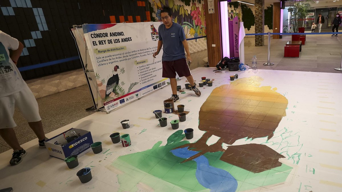 Artistas dibujan un condor en un centro comercial, el 19 de agosto de 2022, en Quito (Ecuador).