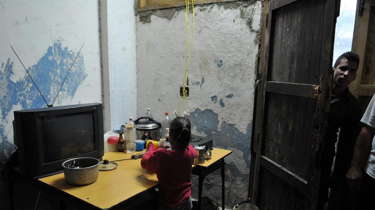 Fotografía de archivo fechada el 10 de septiembre de 2008 que muestra a una niña mientras lava platos en una improvisada cocina en el poblado José Martí, municipio de San Cristóbal, provincia de Pinar del Río (Cuba).