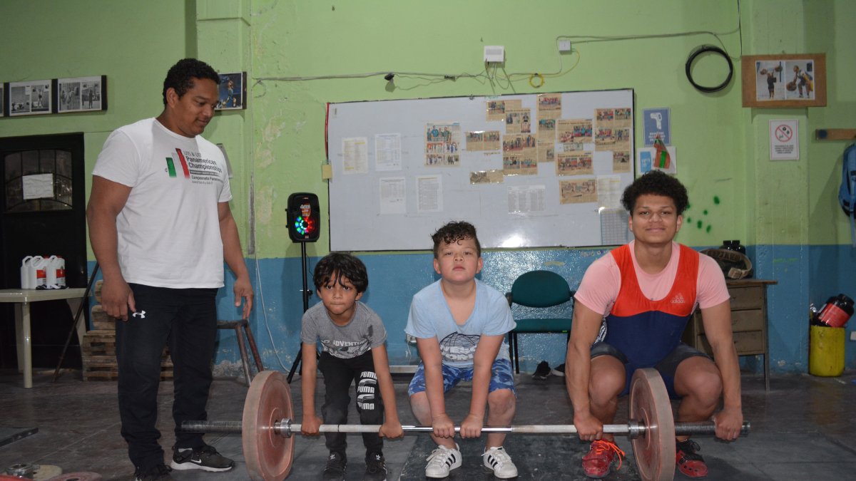 Eduardo Guadamud, entrenador de pesas, con sus hijos, Eduardo, Cristhian y Juan David.