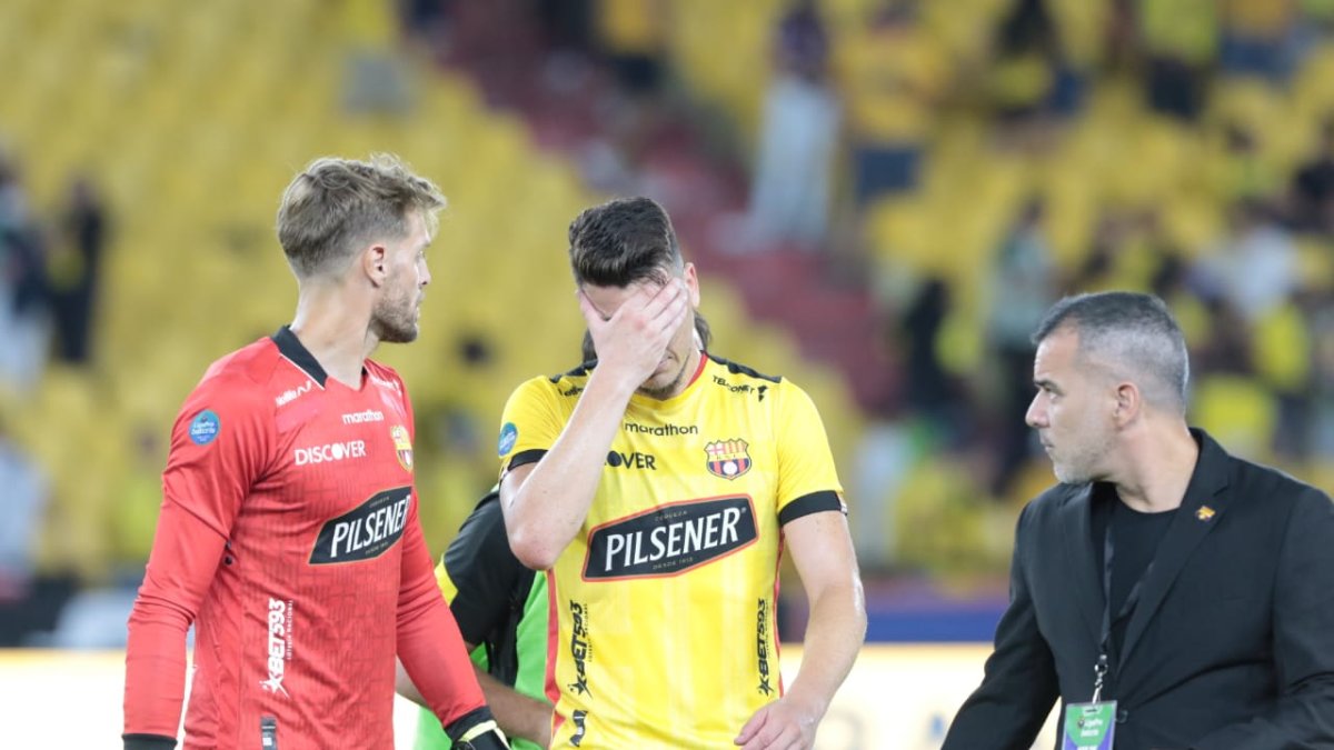 Javier Burrai intenta consolar al defensor amarillo, Paco Rodríguez, quien marcó el gol de Barcelona, pero influyó en el empate final de Liga de Quito.