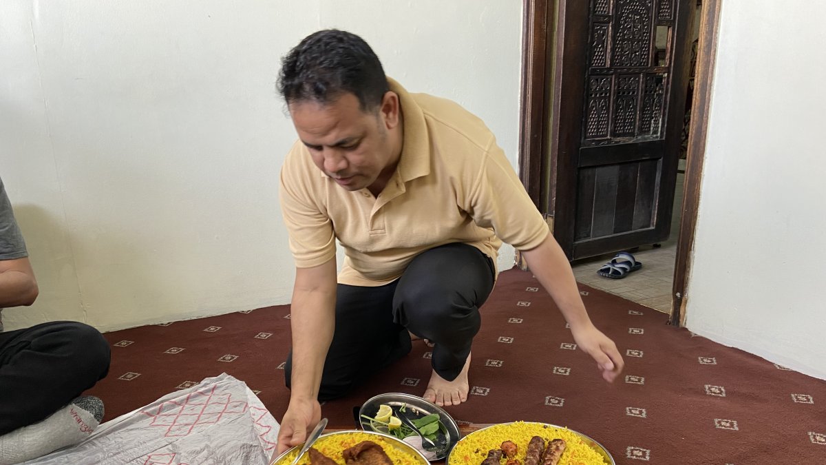 Un residente en Qatar sirve la comida en el piso, como es una de las costumbres en el lugar.