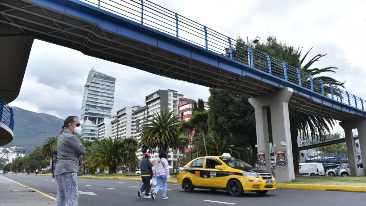 Normalizado. Las personas caminan entre los autos para llegar al otro lado de la calle.